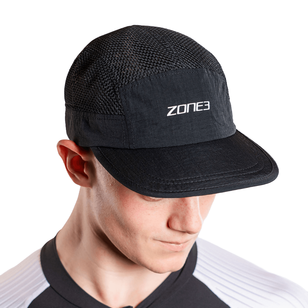 Gorra de malla negra con el logotipo 'Zone3', llevada por una persona, sobre fondo blanco