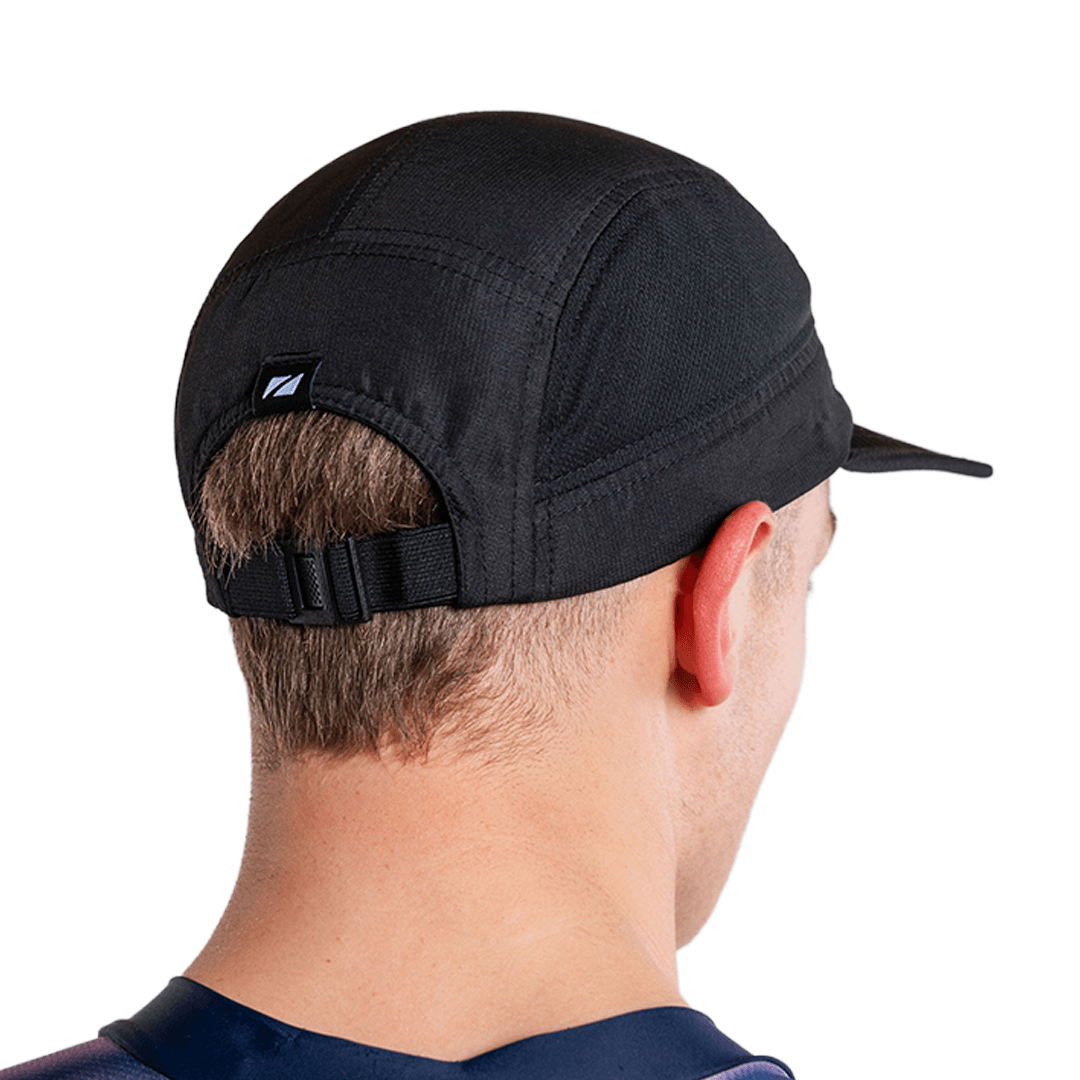 Persona con la gorra de running de 5 paneles en negro y el logotipo de zone3, sobre fondo blanco