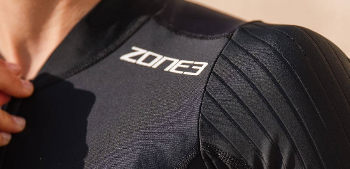 Black trisuit with 'Zone3' branding on a beige background