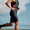 Atleta masculino con el short de triatlón Activate en negro y paneles rojos, corriendo al aire libre.
