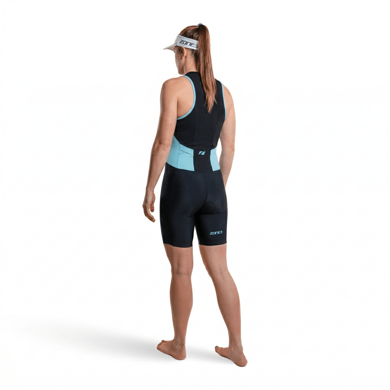 Mujer con el trisuit Activate en negro y azul, vista trasera, sobre fondo blanco