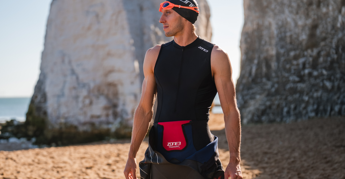 Person on the beach wearing zone3 black activate+ sleeveless trisuit on a blurred background