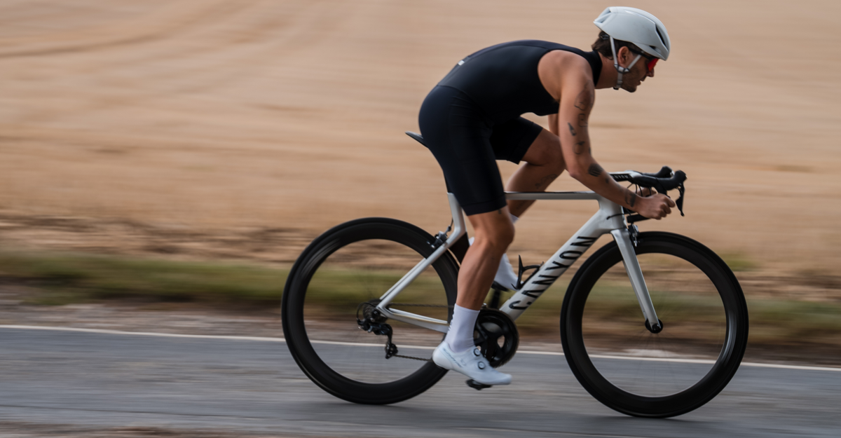 Person cycling wearing zone3 black activate+ sleeveless trisuit on a blurred background