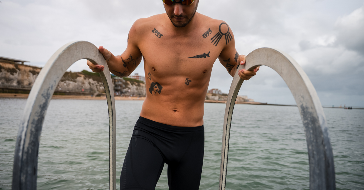 Man with tattoos standing on a bridge over water with a cloudy sky in Zone3 black jammers
