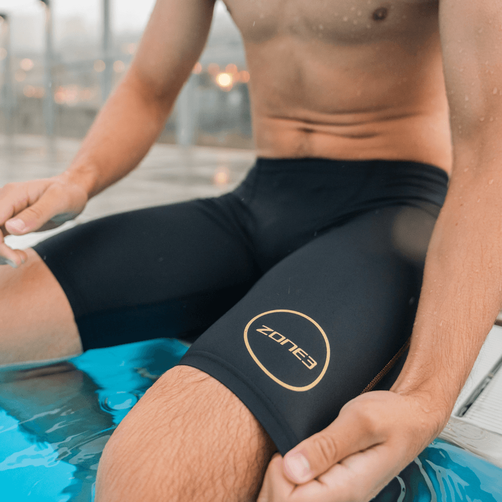 Primer plano de un nadador con jammer MF-X negro y logotipo circular dorado