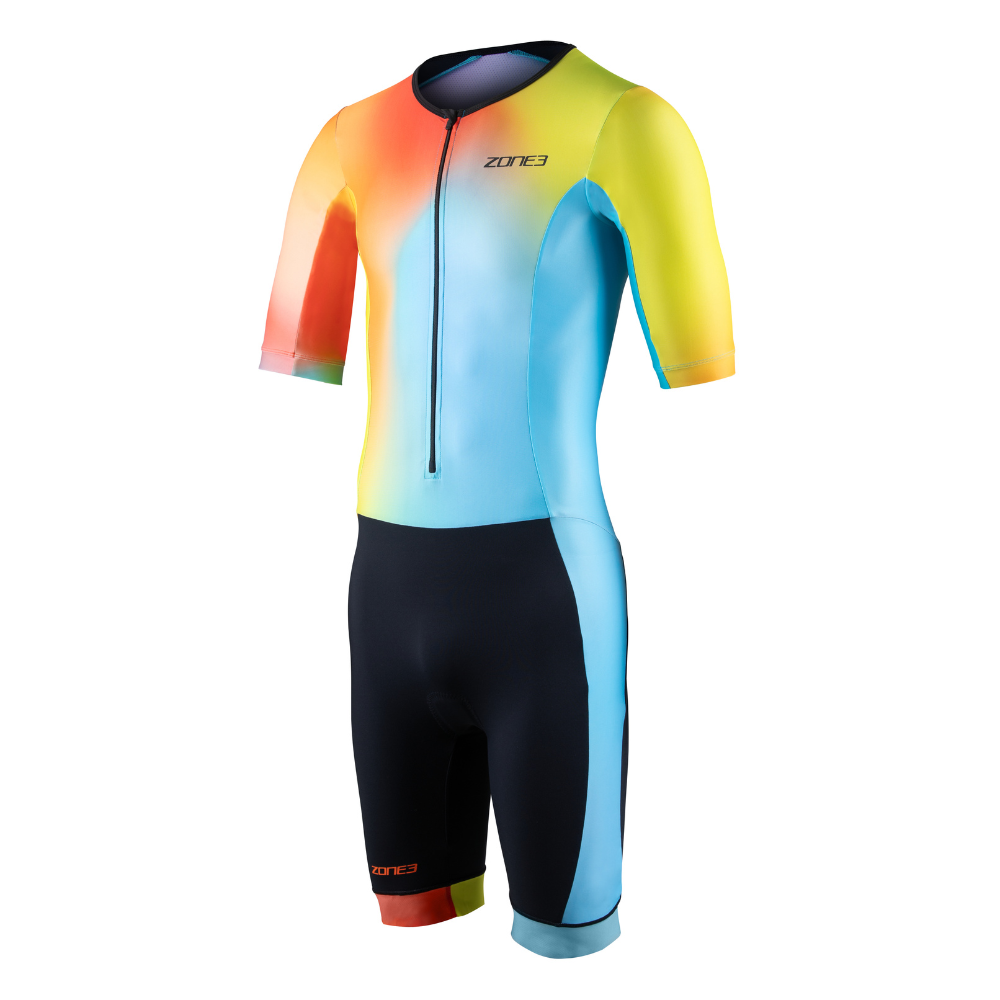 Vista frontal del trisuit Activate+ de manga corta para hombre de ZONE3, con degradado azul, amarillo y naranja en la parte superior y short negro. Cuenta con cremallera frontal y puños de pernera por bloques de color.