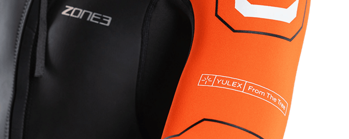 Close-up of a black wetsuit with 'Zone3' branding and an orange buoy with 'Yulex' branding.