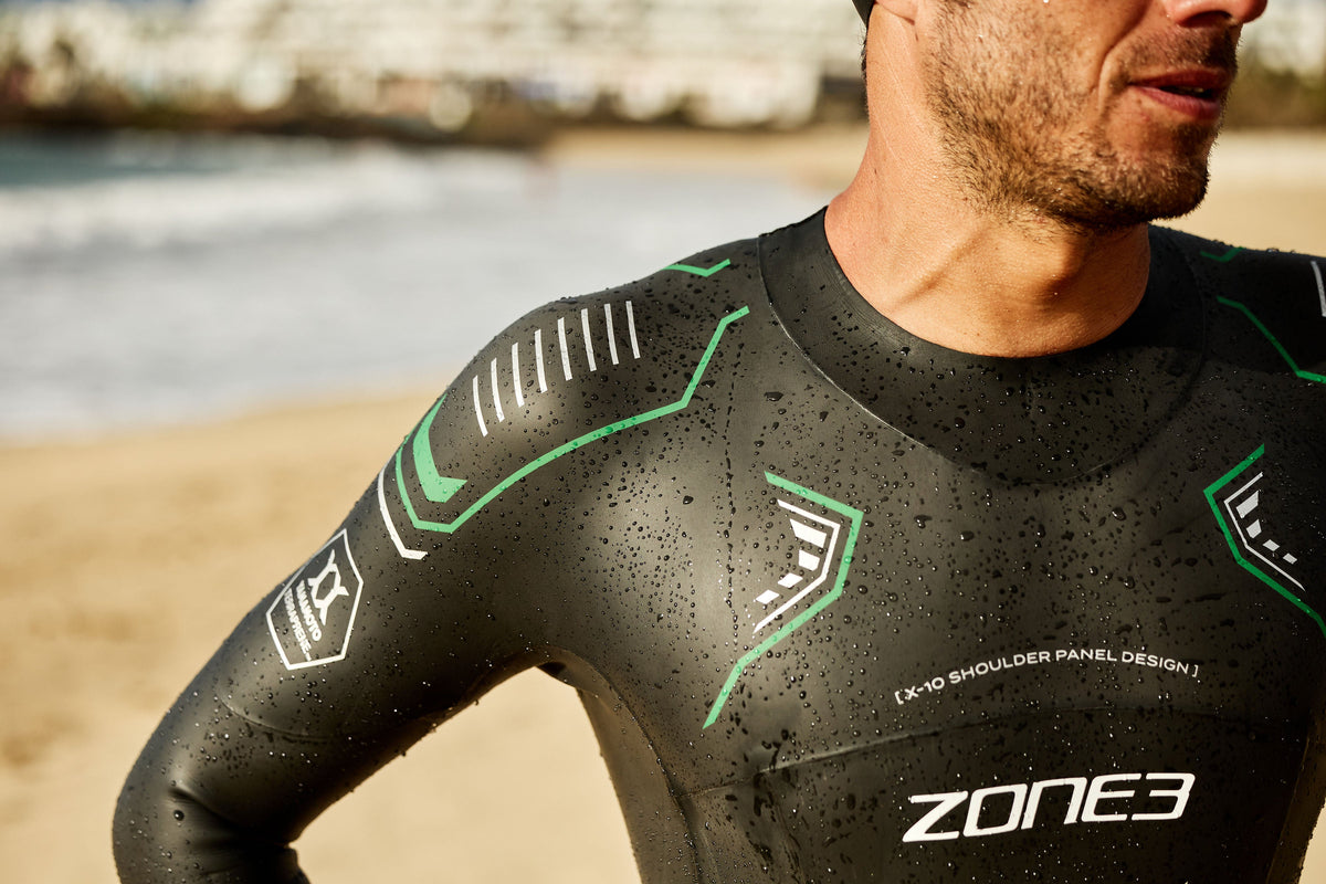 Person wearing a Zone3 wetsuit on a beach