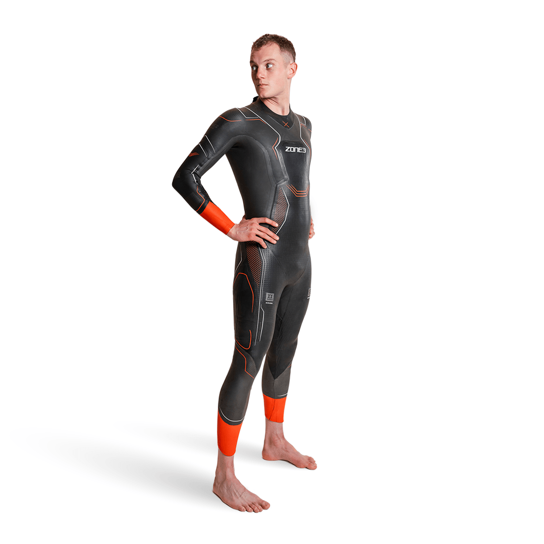 Hombre con el neopreno Vanquish-X en gris oscuro, puños naranjas y paneles geométricos.