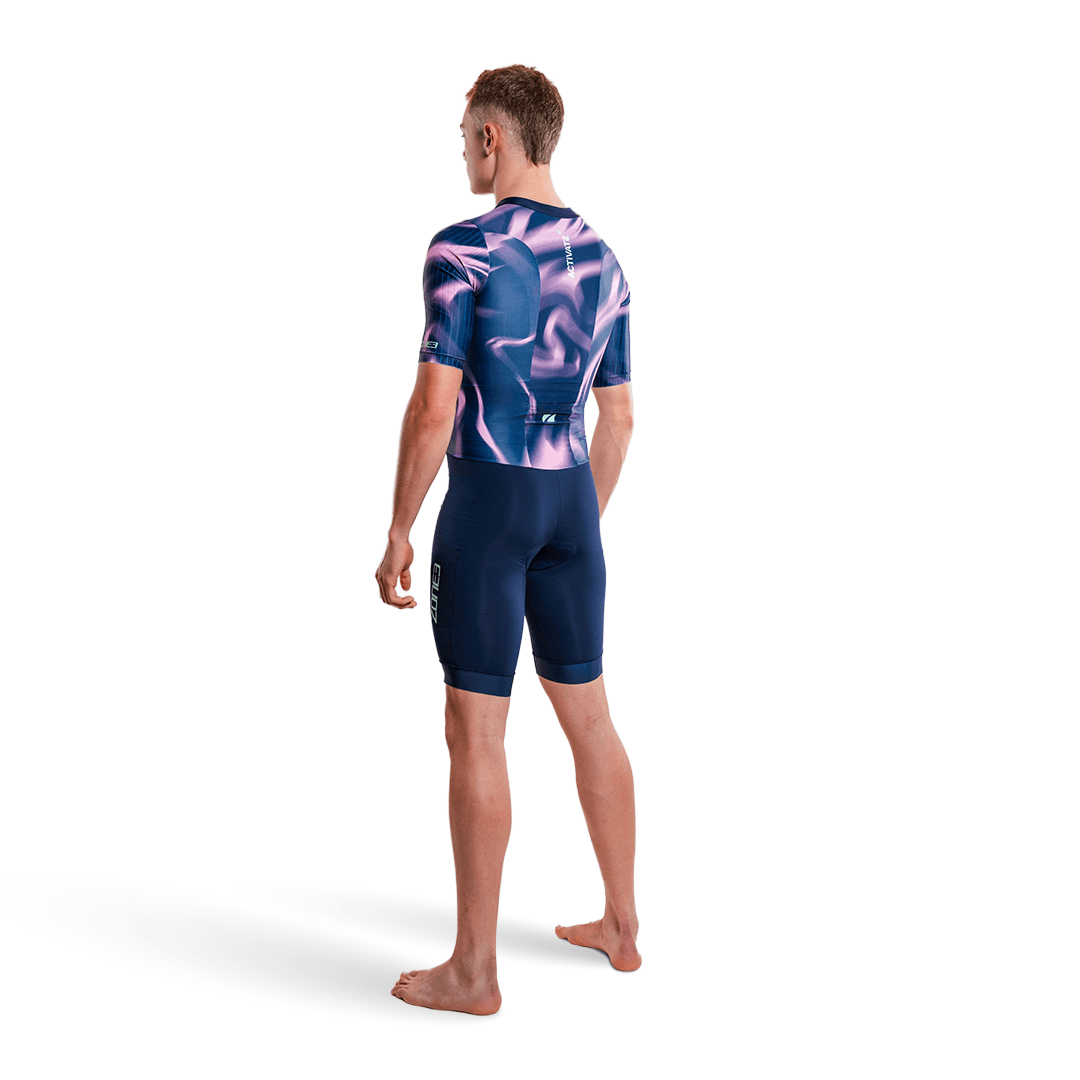Persona con un trisuit morado y rosa, sobre fondo blanco