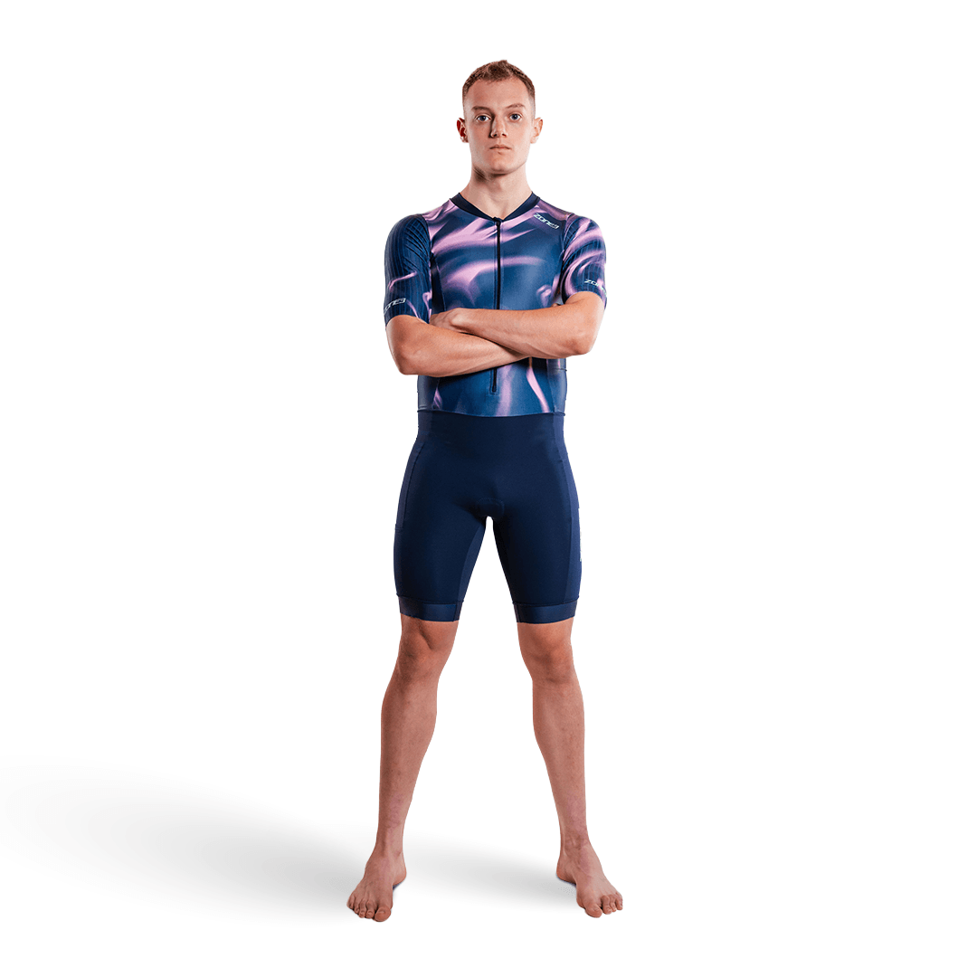 Persona con un trisuit morado y rosa, sobre fondo blanco