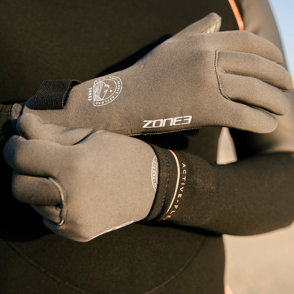 Manos con los guantes de natación Active-Flex, ofreciendo protección para nadar, hacer surf y deportes de remo.