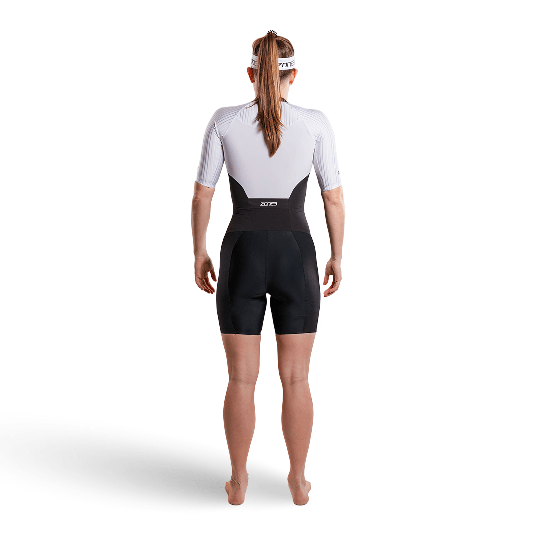 Mujer con el trisuit Lava Long Distance de manga corta y cremallera completa, sobre fondo blanco