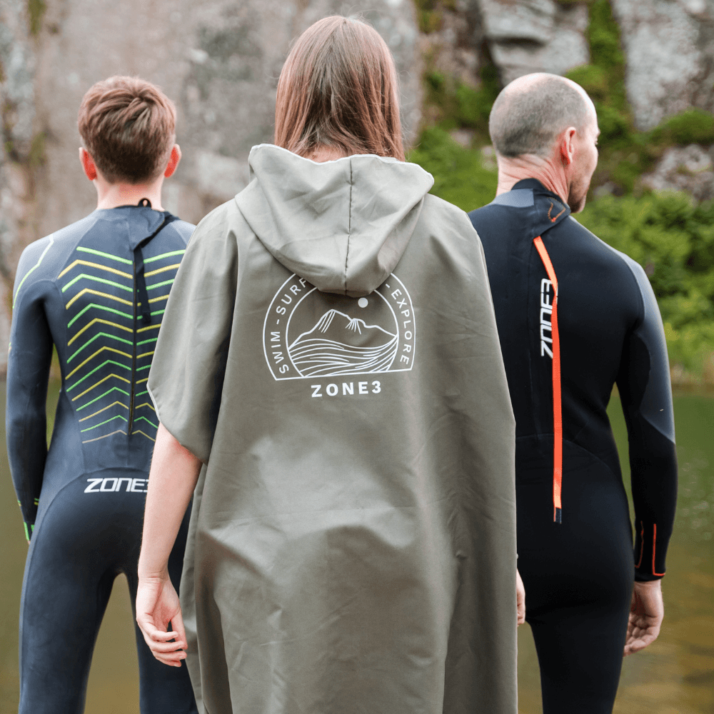 Tres personas con neoprenos y un albornoz de microfibra de Zone3, ideal para nadar al aire libre y para aventuras.