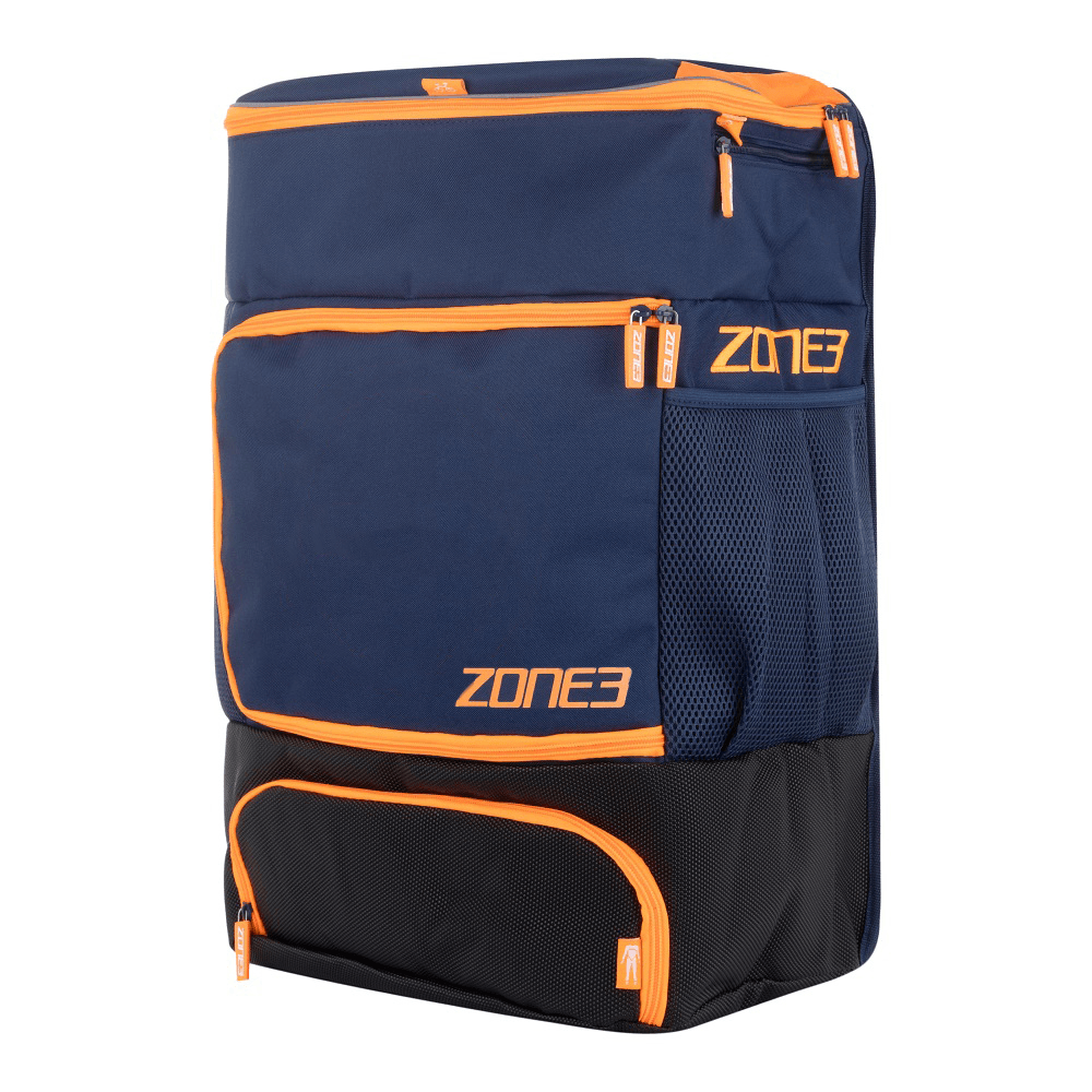 Mochila de transición ZONE3 en azul marino y naranja, con múltiples cremalleras y el logotipo de la marca visible en el lateral.