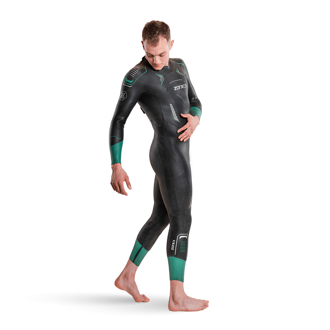 Vista lateral de un hombre con el neopreno Vision en negro y puños verde turquesa en mangas y pantorrillas